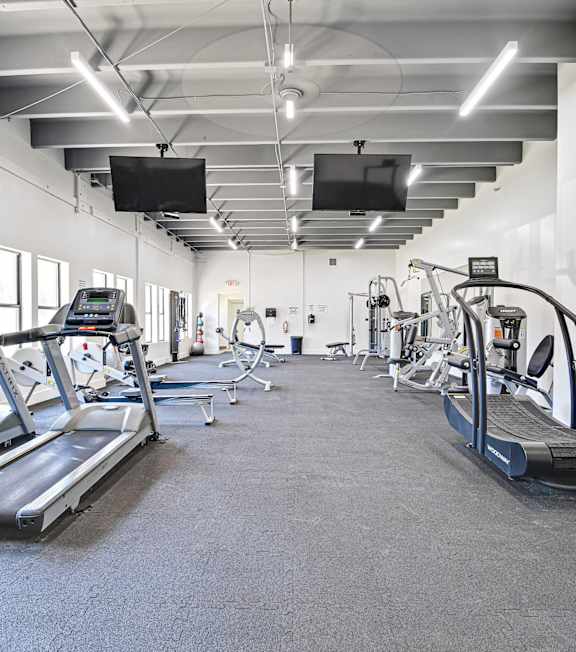 photo of a fitness center with many different pieces of gym equipment. 