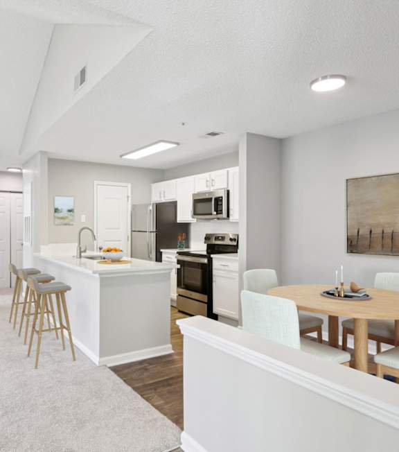 A kitchen with a stove, oven, and a dining table with chairs.