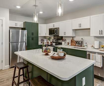 a kitchen with green and white cabinets and a white counter top at Edgebrook Residences, New Hampshire
