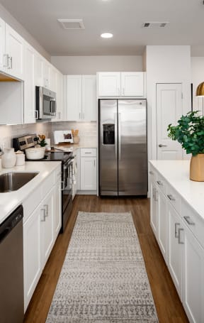 a large white kitchen with white cabinets and stainless steel appliances