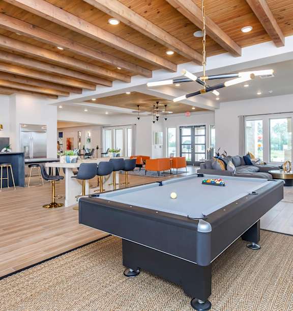 A billiard table is in the middle of a room with a bar and seating area. at Sienna at Westover Hills Apartments, San Antonio, TX 78253