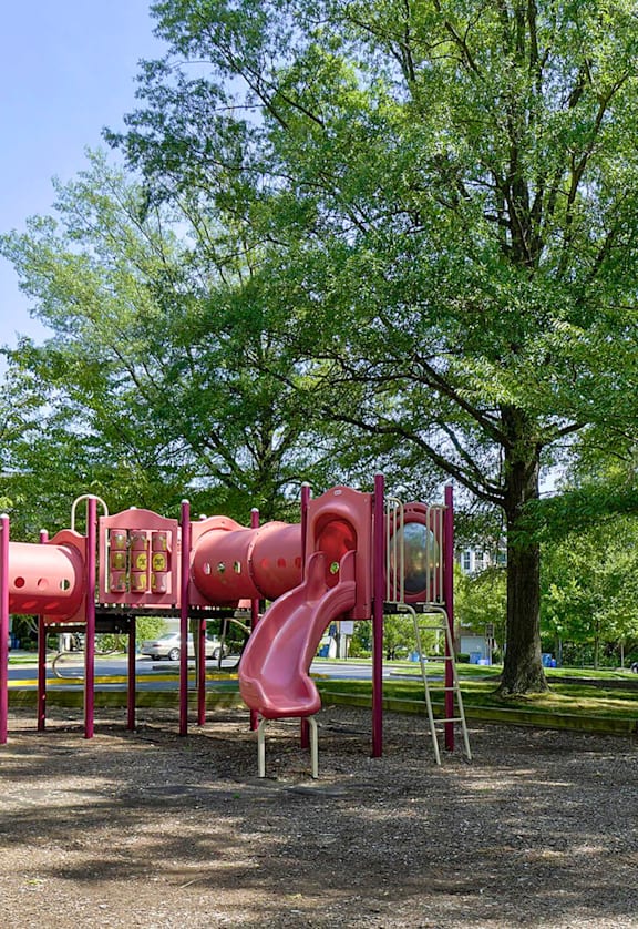 A playground with red slides and a white slide.