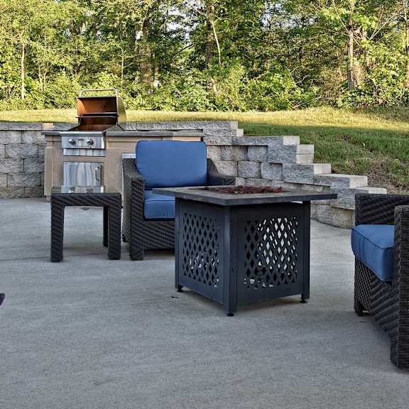 A patio with a table and chairs and a fire pit.