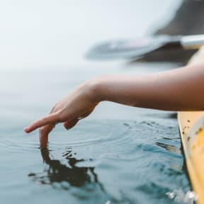 Woman in Kayak Putting Hand in Water
