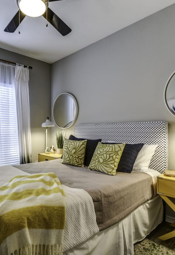 a bedroom with a bed and a mirror on the wall
