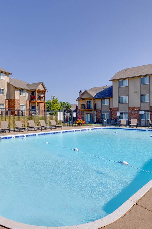 Crystal-clear pool at Regency Woods Apartments with plenty of space to lounge.