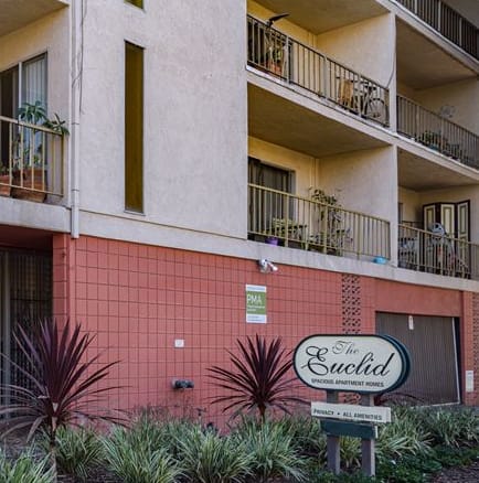 an apartment building with a sign in front of it
