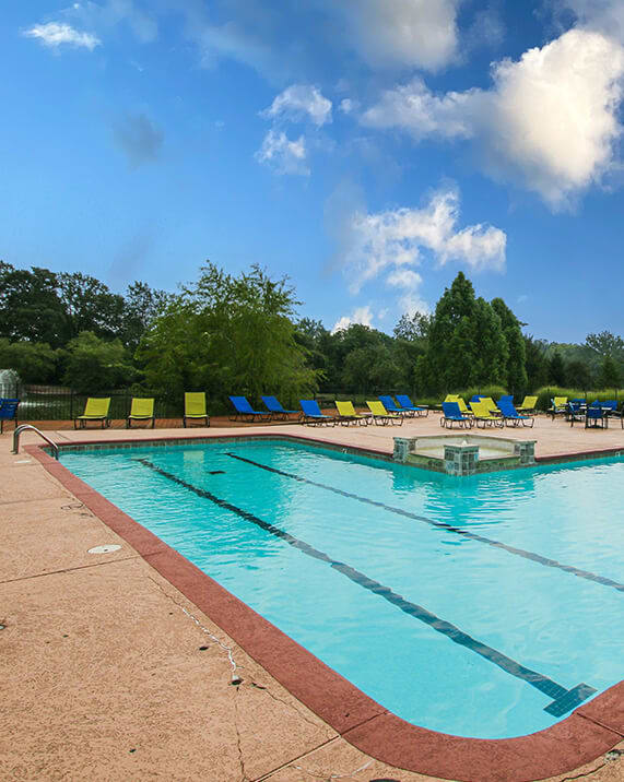a large swimming pool with chairs around it
