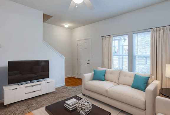 A living room with a white couch and a television.