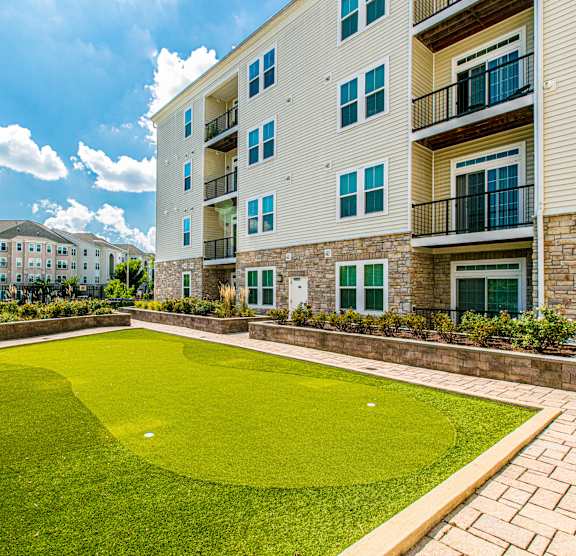 A large grassy area in front of a building. at Kensington Place Apartments, Woodbridge