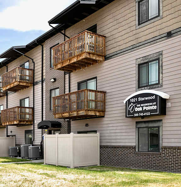 Apartment complex with a sign that says "1021 Starwood at Oak Pointe" and a phone number.