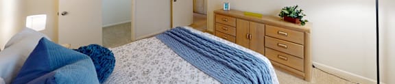 A bedroom with a bed, nightstand, and lamp.