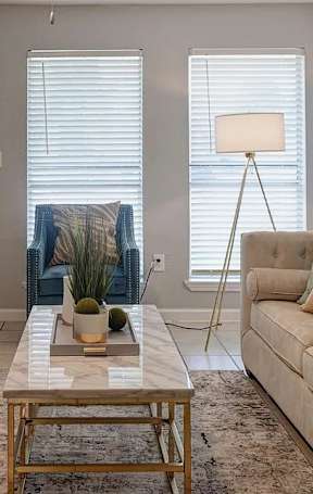 A living room with a couch, a coffee table, and a painting on the wall.