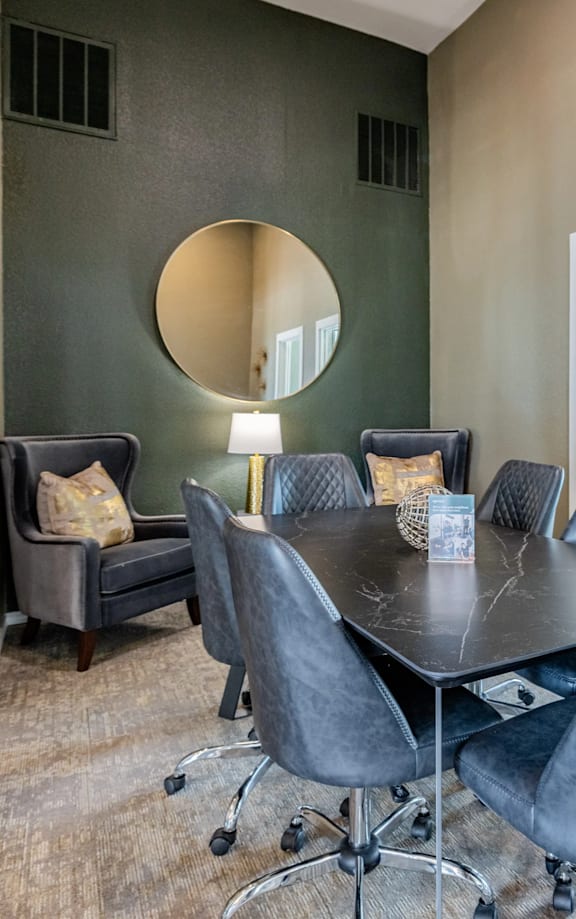A modern living room with a large desk and chairs.