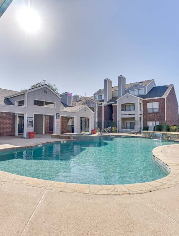 A swimming pool in a residential area with houses in the background.