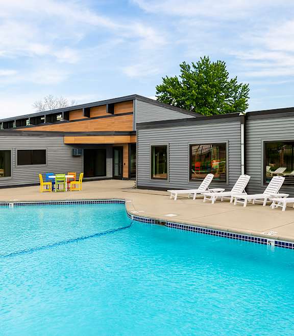 a large pool with chairs and a fence around it at The Bosk Apartment Homes, Woodbury, MN