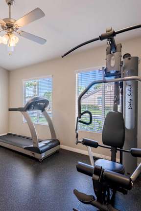 A home gym with a treadmill, elliptical trainer, and a stationary bike.