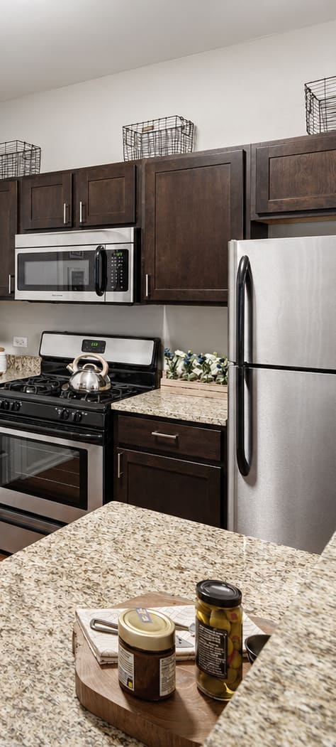 A kitchen with a sink, refrigerator, and microwave.