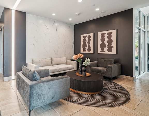 a lobby with couches and chairs and a rug
