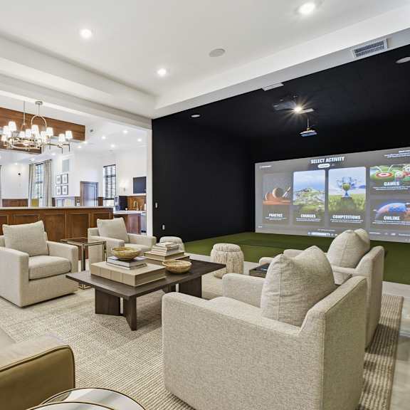 A living room with a brown couch and a chandelier.