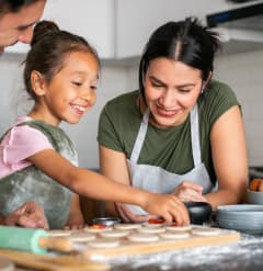 a mother and father making cookies with their daughter in the kitchen at North Grove, Riverside California