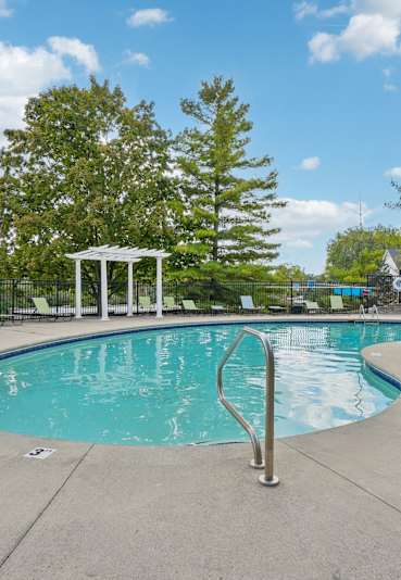A pool with sun chairs and blue skies