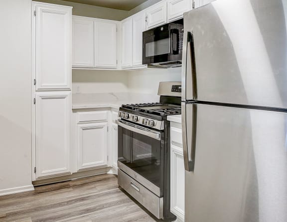 a kitchen with stainless steel appliances and white cabinets