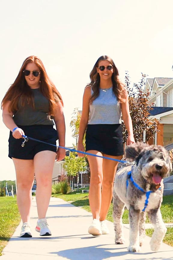 Two women walking a dog on a leash. at Sagebrook Apartments, La Vista, Nebraska