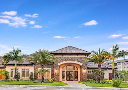 A building with a stone facade and palm trees in front.