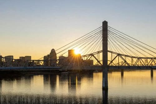 a bridge over a body of water with a sunset