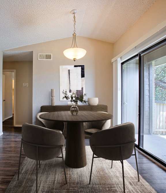 A dining room with a table and chairs.