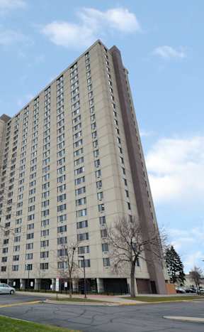 A large building with a parking lot in front.