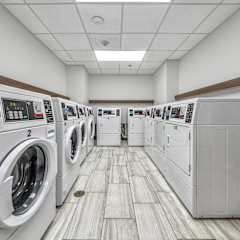 a bunch of washers and dryers in a laundry room