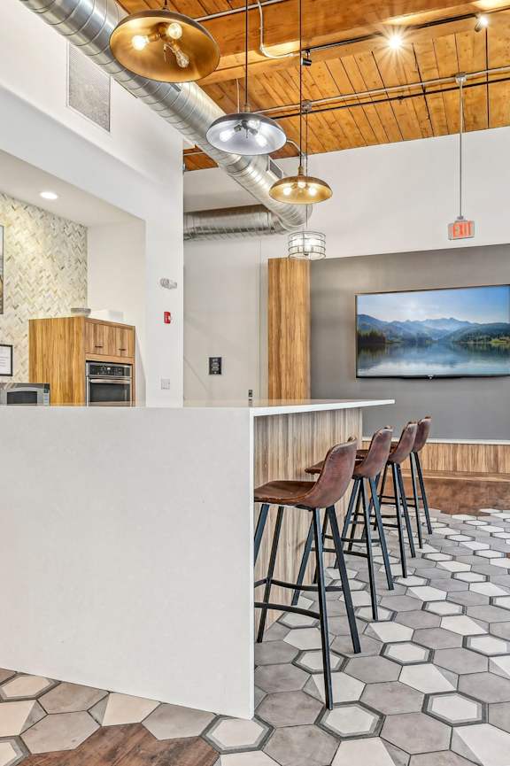 A modern kitchen with a white island and bar stools at Riverwalk Apartments, Lawrence, Massachusetts 01843