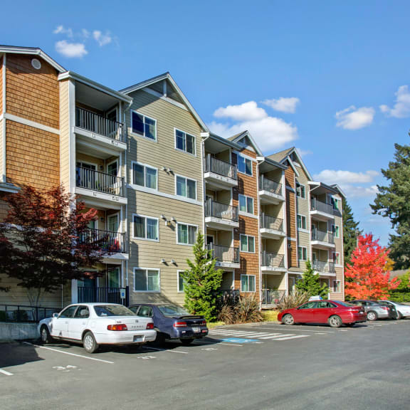 an apartment building with cars parked in a parking lot