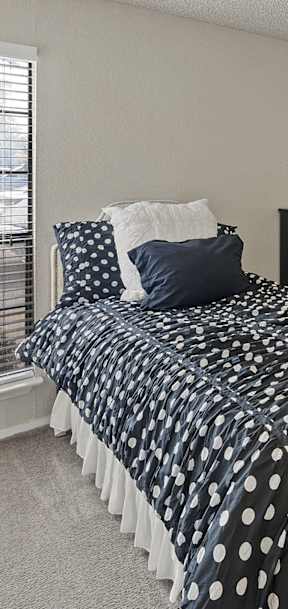 a bedroom with a bed and a large window at Parks on the Green, Temple, TX