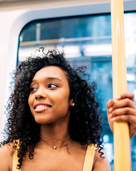 a woman riding a subway train holding on to a pole at Novella Arcadia, Phoenix, 85018