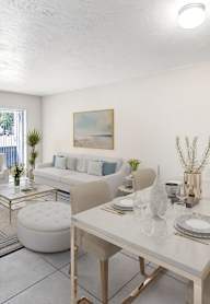 A dining room with a white table and chairs.