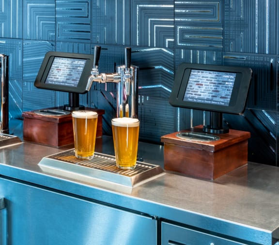 a bar with four glasses of beer on a counter
