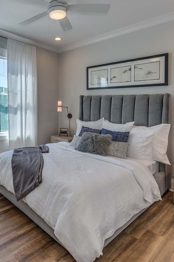 A bedroom with a large bed and a ceiling fan.