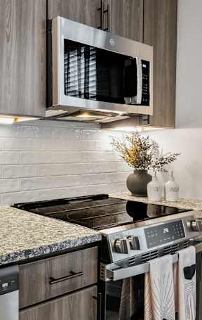 A kitchen with granite countertops and a microwave above the stove.