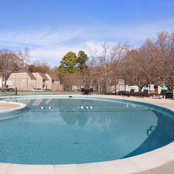 A brick building with a balcony and a tree in front. at Lakes Edge Apartments, North Carolina