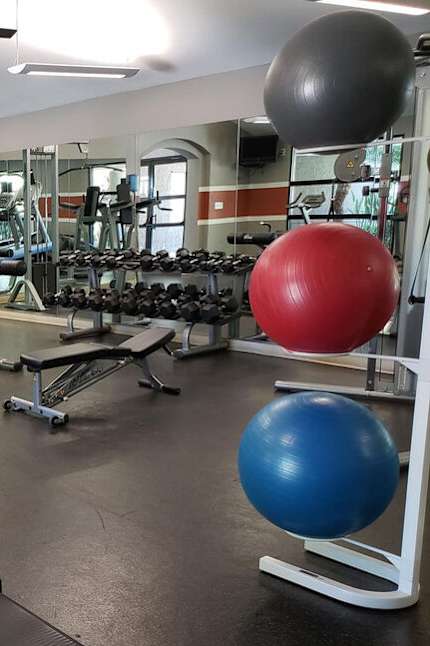 A gym with treadmills, dumbbells, and exercise balls.at Solterra At Civic Center, Norwalk, CA