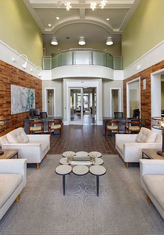 A spacious living room with white furniture and a wooden accent wall.