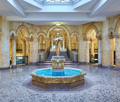 a large lobby with a fountain and a glass ceiling