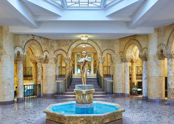 a large lobby with a fountain and a glass ceiling