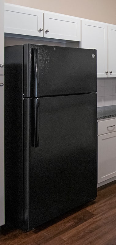 a kitchen with white cabinets and a black stove and refrigerator
