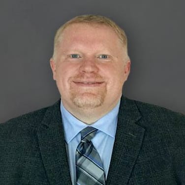 a man wearing a suit and tie and smiling