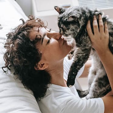 a woman laying in bed with a cat on her face at BrookStone Village, Cincinnati OH