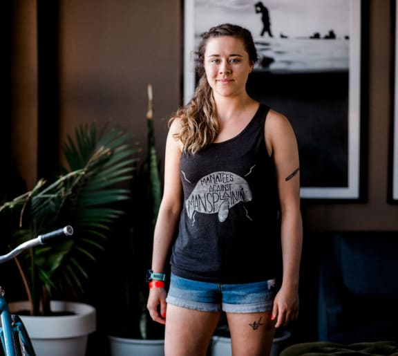 a woman standing in a living room next to a bike